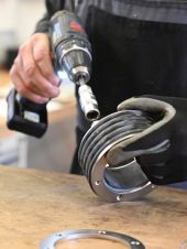 Person zieht Schraube an einem Pressring fest.