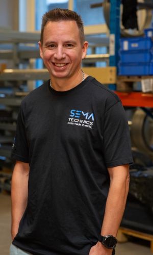 Marco Lehmann mit Sema Technics AG Shirt porträtiert vor Gestell mit Pressringen.